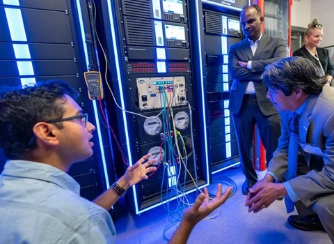 two people look at a computer server